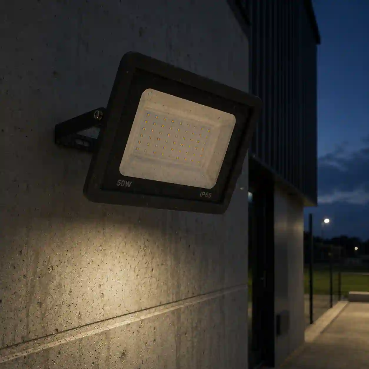 Rozsvícený LED reflektor LEVE 50W osvětlující venkovní plochu studenou bílou barvou světla s úhlem 120 stupňů